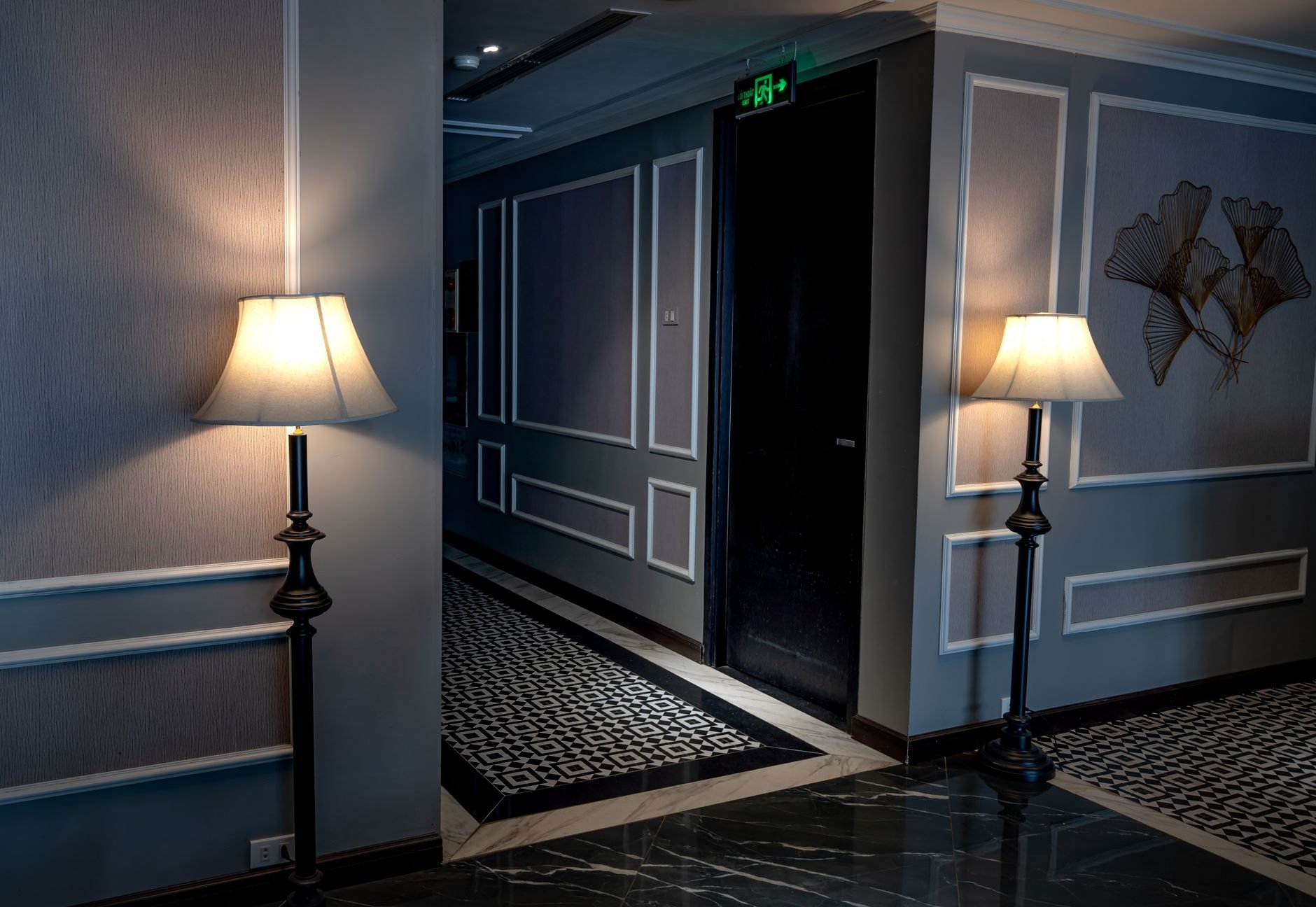 Luxurious hotel corridor with stylish lamps and decorative wall panels.