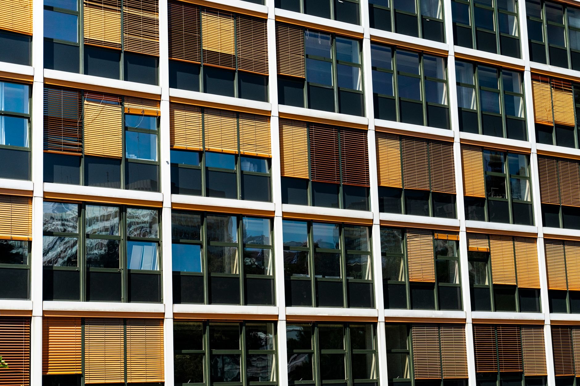 Contemporary glass facade of an office building in Lausanne, Switzerland, showcasing reflections and sunlight.
